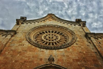Low angle view of old building against cloudy sky