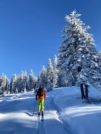 Man skiing on snowcapped mountain against sky