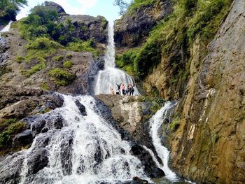 People against waterfall on mountain