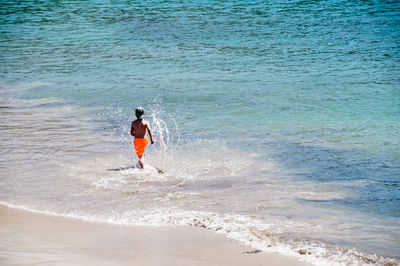 Rear view of man standing on beach