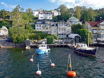 Boats moored in river by buildings in city