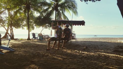 People at beach against sky