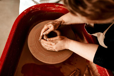 Midsection of woman making pottery