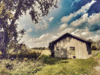 Abandoned building on field against sky