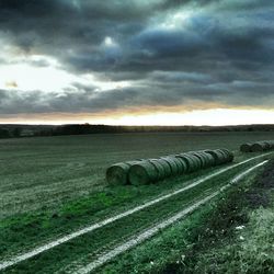 Scenic view of field against cloudy sky