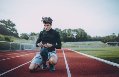 Full length portrait of boy running on landscape against clear sky