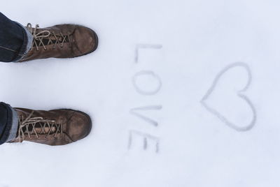 Low section of man standing on snow