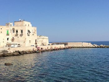 Calm sea with buildings in background