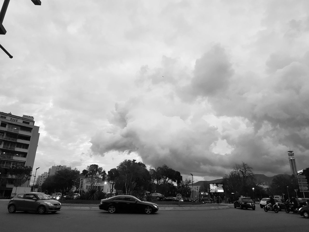 CARS ON ROAD BY BUILDINGS AGAINST SKY