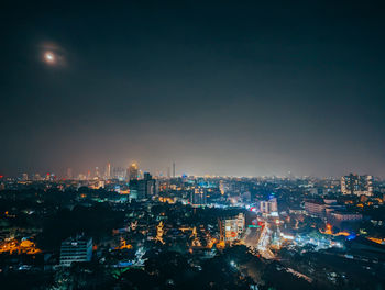 Illuminated cityscape against clear sky at night