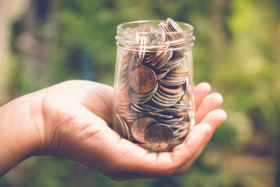 Close-up of hand holding glass jar