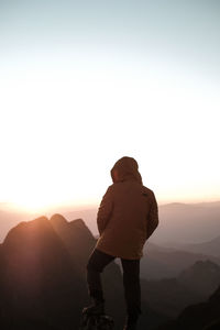 A man is standing on the peak of the mountain