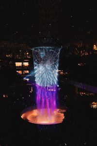 Illuminated fountain in city at night