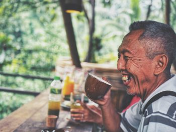 Portrait of the happy old man having a cup of coffee