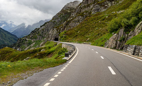 Road by mountains against sky