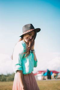 Woman wearing hat while standing on land against sky