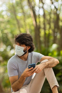 Young man at park on a beautiful sunny day with mobile phone.  working  leisure. green and nature 