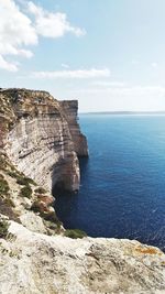 Rock formations by sea against sky