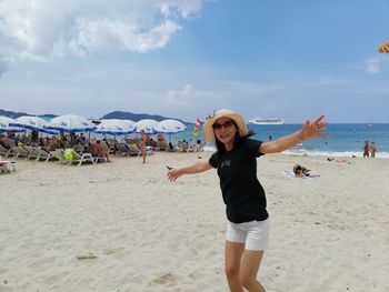 Full length of smiling young woman on beach