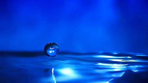 Close-up of drop on blue water