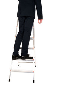 Low section of man standing against white background