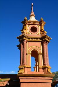 Low angle view of clock tower against clear blue sky