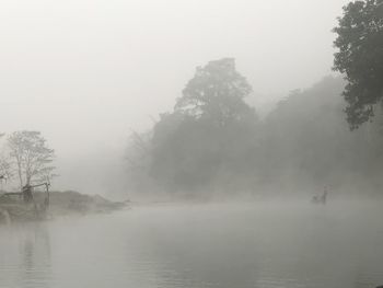 Scenic view of lake against sky at foggy weather