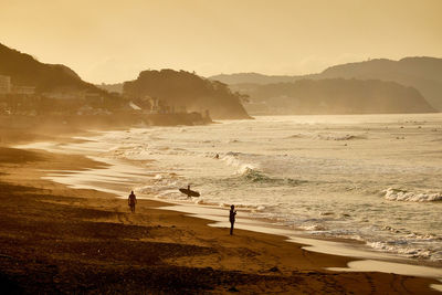 People on beach against sky