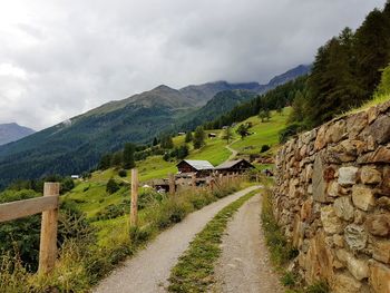 Scenic view of road by mountains against sky