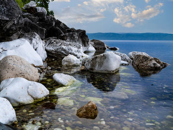 Rocks in sea against sky