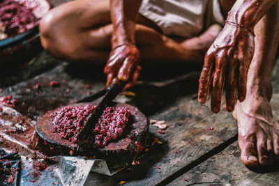 Close-up of butcher mincing meat with knife at shop