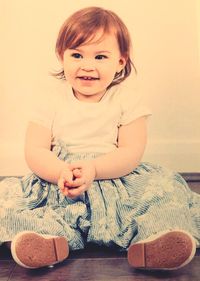 Portrait of smiling girl sitting on floor