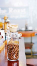 Close-up of roasted coffee beans in jar on wooden table