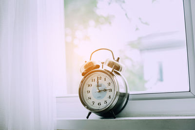 Alarm clock by window at home