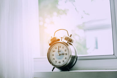 Close-up of clock on table at home