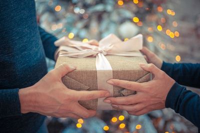 Midsection of woman holding gift with men