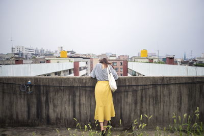 Rear view of woman standing on building terrace