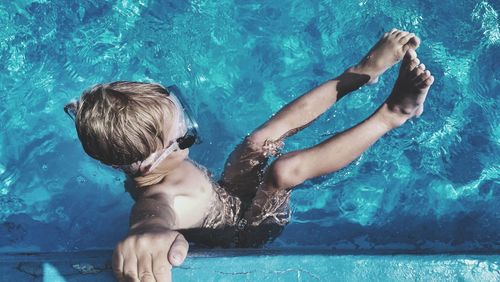 Full length of shirtless boy swimming in pool