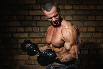 Side view of man exercising against black background