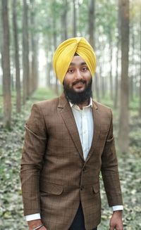 Portrait of young man standing in forest