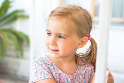 Portrait of a happy blonde girl with a ponytail smiling and making eye contact with the camera.