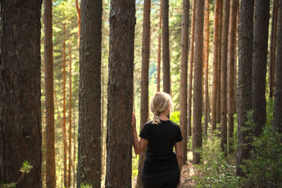 Beautiful adult woman in sunny pine forest, idea of health restoration and relaxation, forest baths