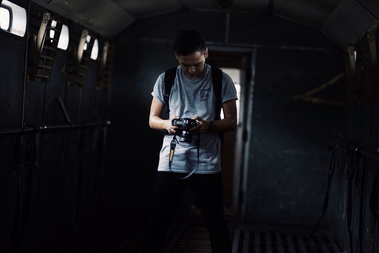 indoors, young adult, lifestyles, casual clothing, full length, person, standing, young men, leisure activity, front view, three quarter length, looking at camera, portrait, architecture, sitting, technology, contemplation