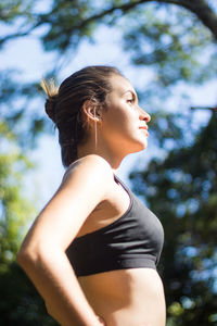 Low section of woman looking away against trees