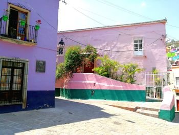 Houses by street in town against sky