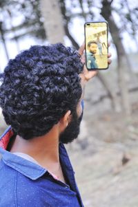 Portrait of man photographing with mobile phone