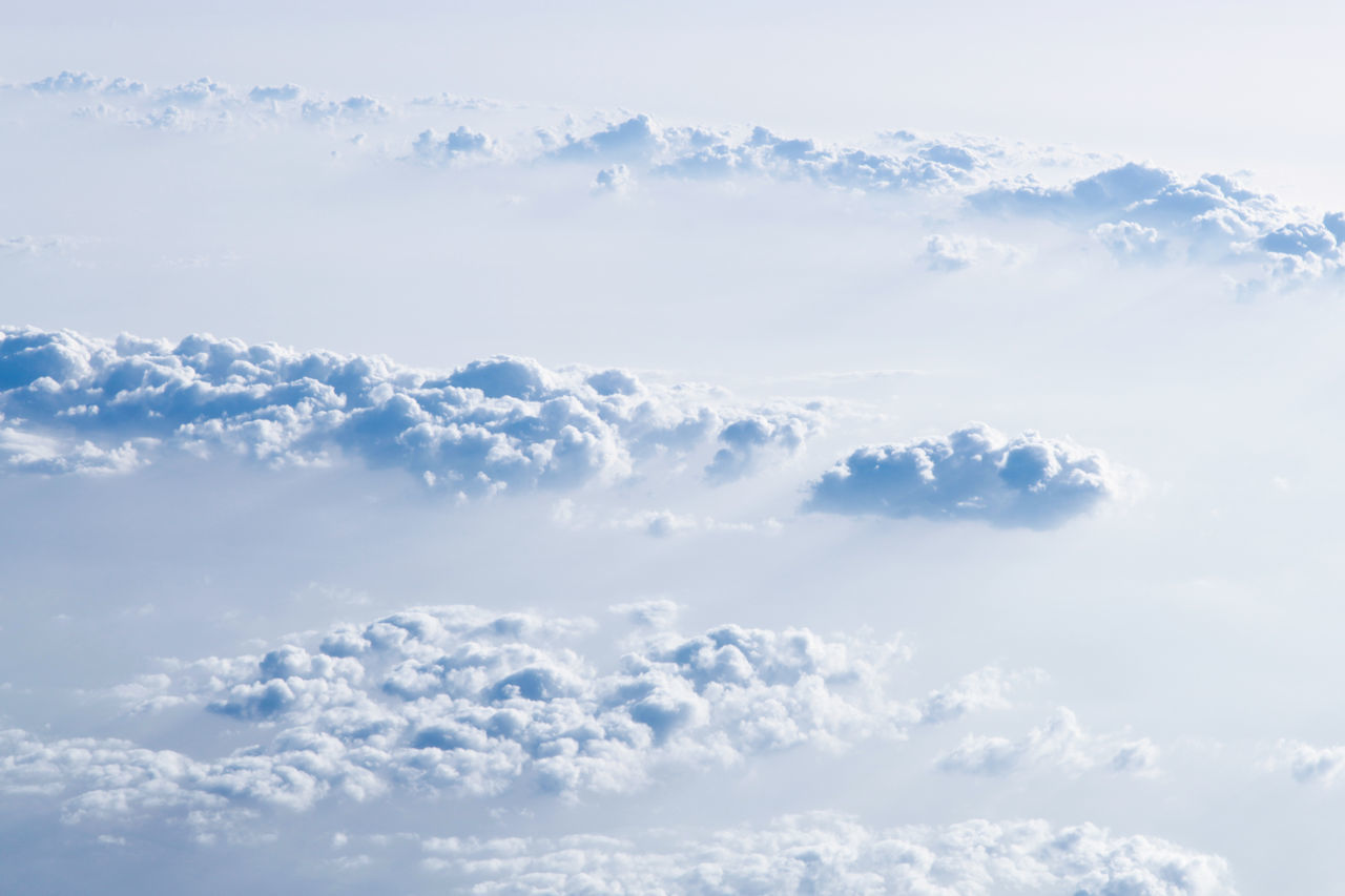 sky, cloud, environment, beauty in nature, blue, nature, scenics - nature, daytime, cloudscape, white, idyllic, tranquility, no people, snow, backgrounds, winter, outdoors, overcast, day, cold temperature, landscape, fluffy, tranquil scene, sunlight, atmosphere, flying, aerial view, high up, copy space, travel, airplane, clear sky, wind