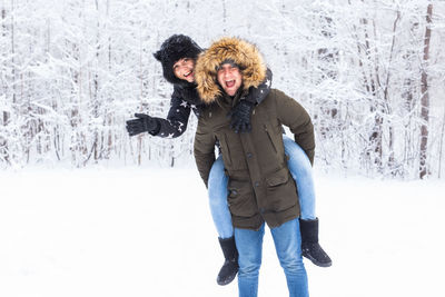 Portrait of smiling woman standing in snow