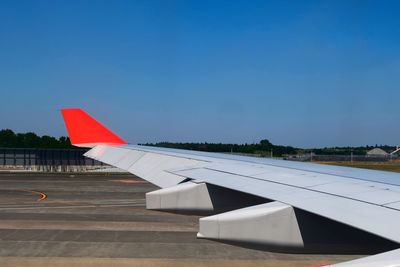 Airplane on airport runway against clear blue sky