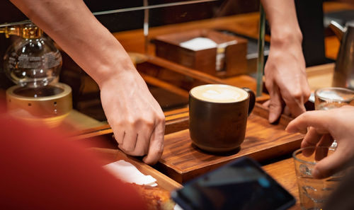 Midsection of woman holding drink at restaurant